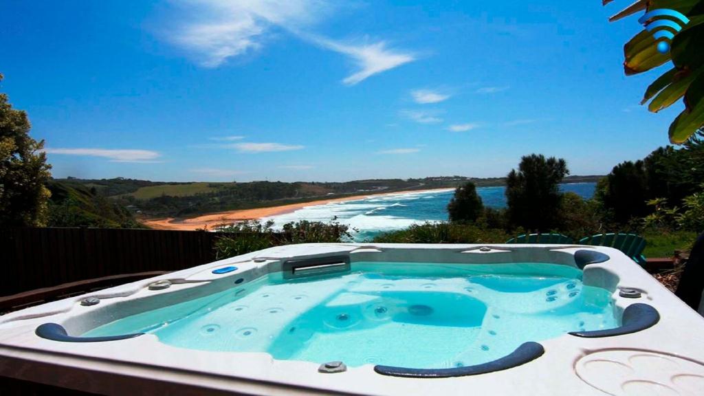 a hot tub with a view of the beach at Santa Barbara on Bombo Beach in Kiama