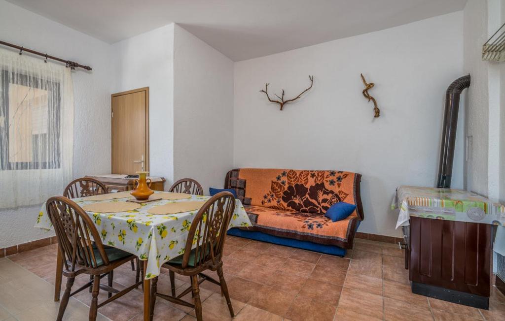 salon ze stołem, krzesłami i kanapą w obiekcie Apartmani Mile w Krku
