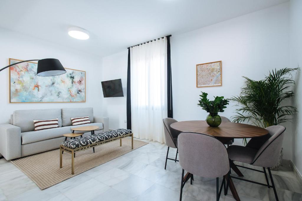 a living room with a table and a couch at Magno Apartments Redes Terrace in Seville
