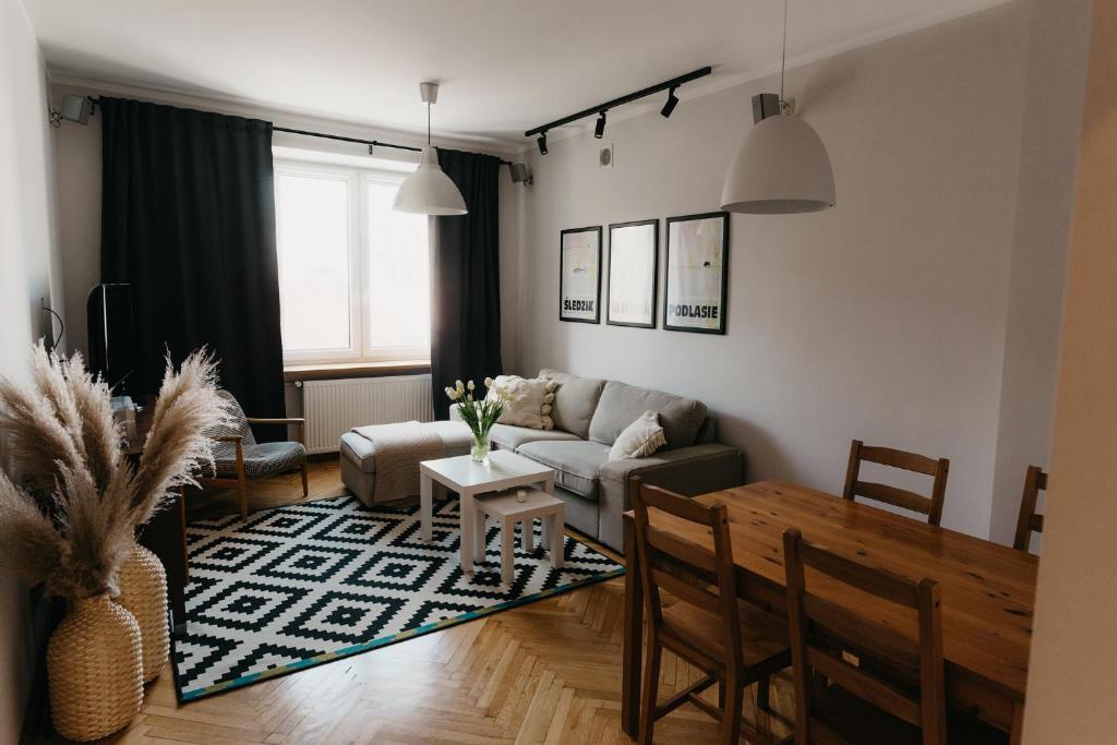 salon z kanapą i stołem w obiekcie Flathouse Apartment Centrum w mieście Białystok