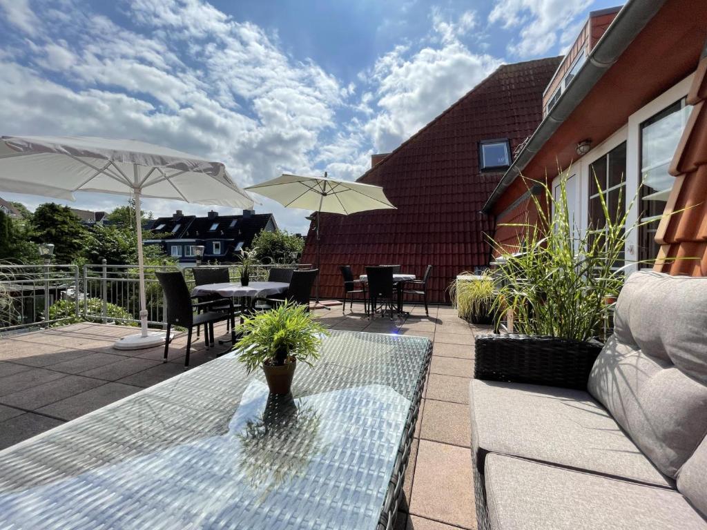 a patio with a table and chairs and umbrellas at Appartement-Service-Laboe in Laboe