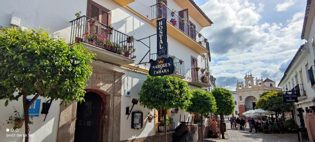 a street with a building with a sign for a hotel at Hostal Rural Marques de Zahara in Zahara de la Sierra