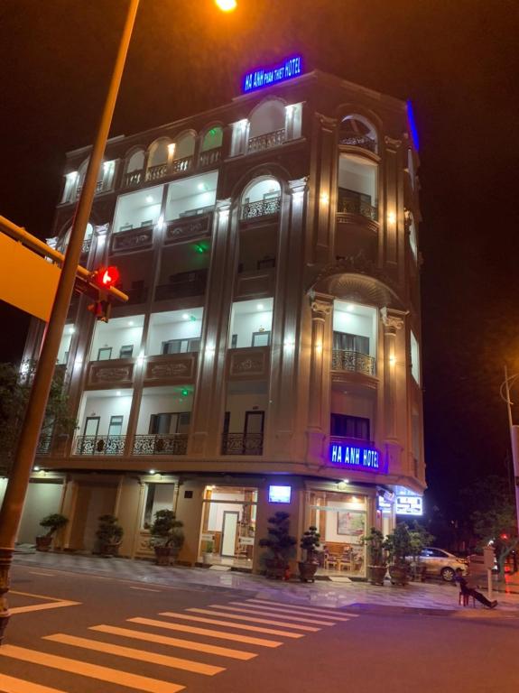 un grand bâtiment avec un panneau la nuit dans l'établissement HA ANH PHAN THIẾT HOTEL, à Phan Thiết