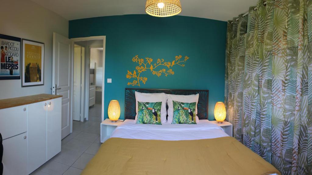 ein Schlafzimmer mit einem Bett mit blauen Wänden und 2 Lampen in der Unterkunft Bel Air -les Restanques in La Ciotat