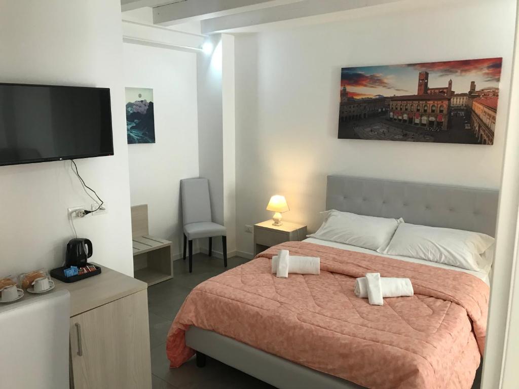 a bedroom with a bed and a flat screen tv at La Corte del Sant'Orsola in Bologna