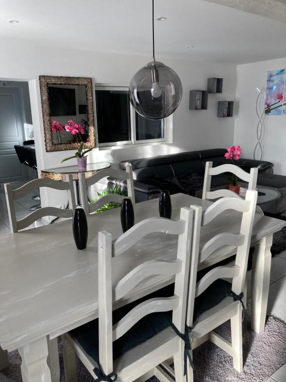 een eetkamer met een witte tafel en stoelen bij Angelina in Chabris