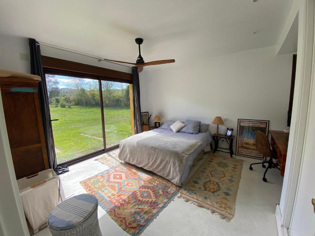 AuñónにあるCasa Rural en el Pantano de Bolarque primera linea del lagoのベッドルーム1室(ベッド1台、大きな窓付)