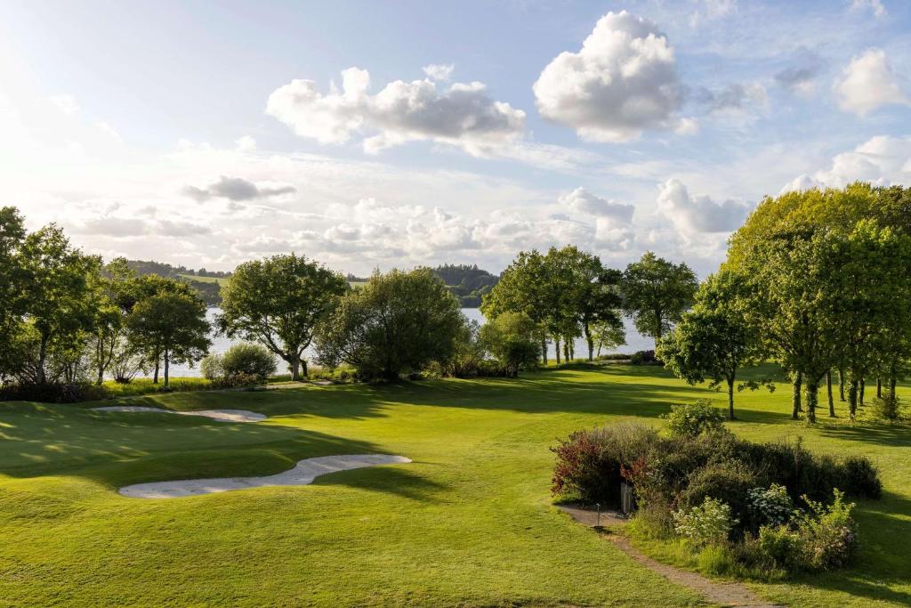プロエルメルにあるBest Western Plus Le Roi Arthur Hôtel & Spaのゴルフコースの景色を望む緑豊かな客室です。
