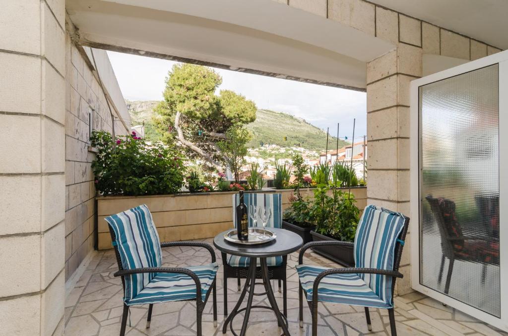 un patio con 3 sillas y una mesa en el balcón en House Apartments Ariva, en Dubrovnik