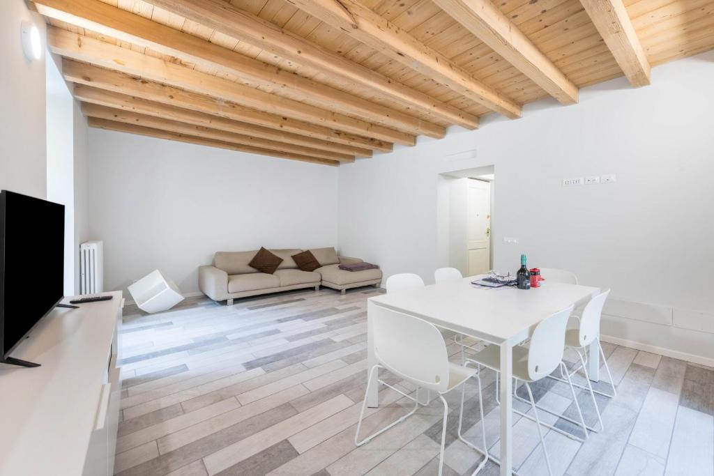 uma sala de jantar branca com uma mesa e cadeiras brancas em Il Golfo Apartments Duplex em Toscolano Maderno