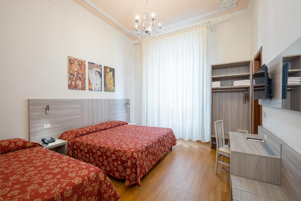 Habitación de hotel con 2 camas y mesa en Lilium Hotel en Florence