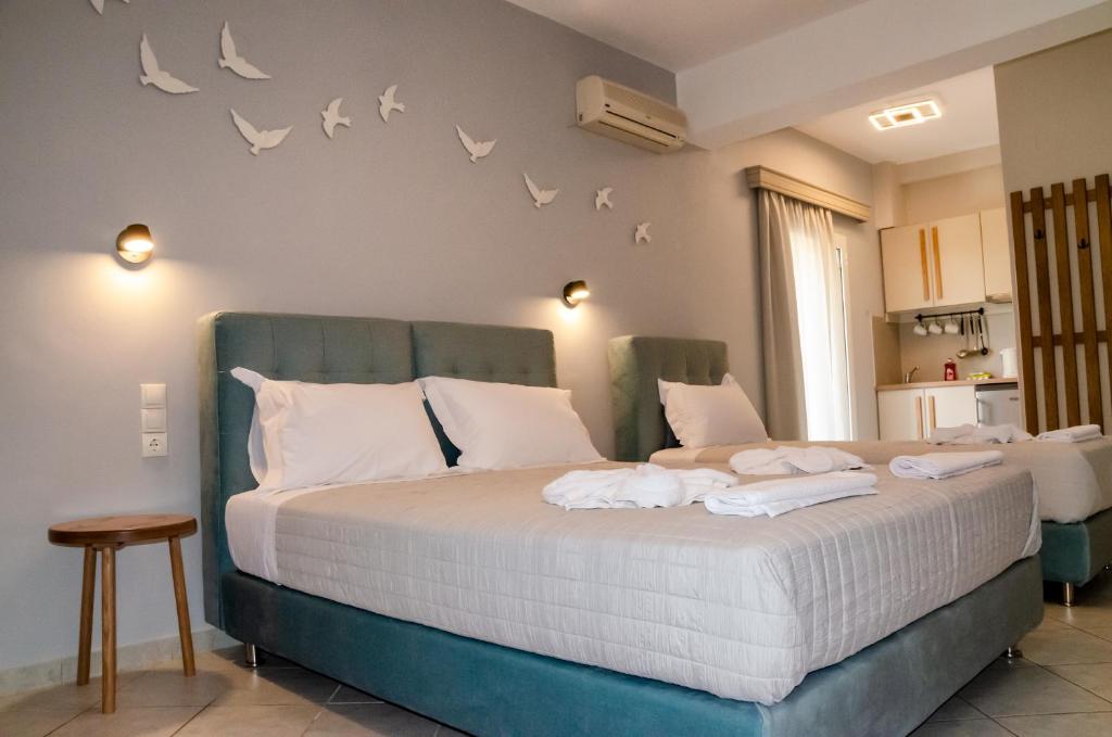 a bedroom with a bed with birds on the wall at Aliki Studios in Parga