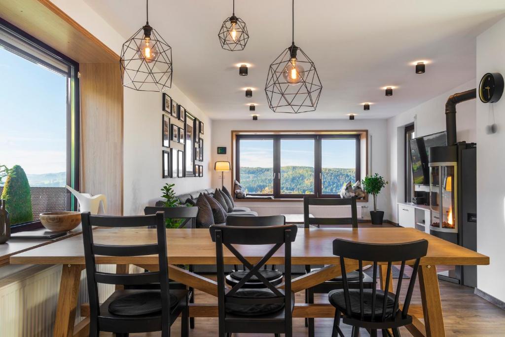 a dining room and living room with a table and chairs at Place 4you in Grafenau