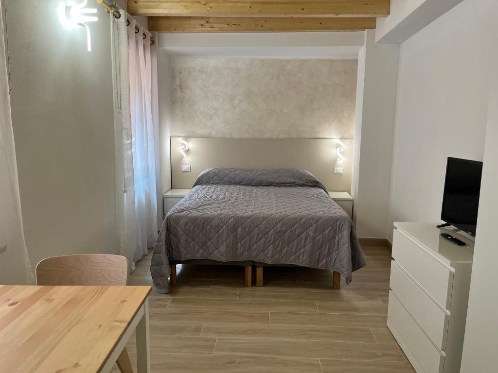 sypialnia z łóżkiem, biurkiem i telewizorem w obiekcie Anfite Apartments Santa Maria w mieście Desenzano del Garda