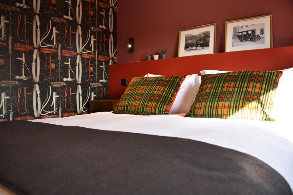 um quarto com uma cama com duas almofadas verdes em Masonic Arms Gatehouse em Gatehouse of Fleet