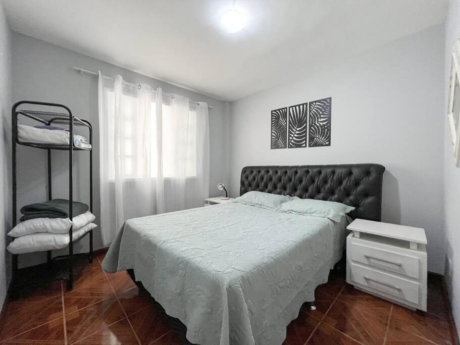 Un dormitorio con una cama grande y un estante en Refúgio em Petrópolis en Petrópolis
