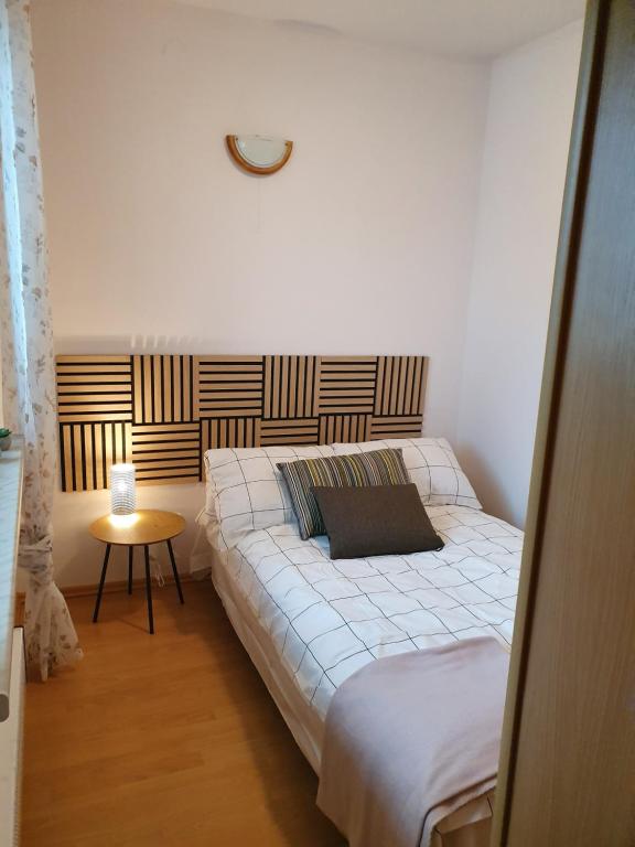 a bedroom with a large bed and a table at Apartament 7 Bystrzycka - Bliżej Zdroju in Polanica-Zdrój