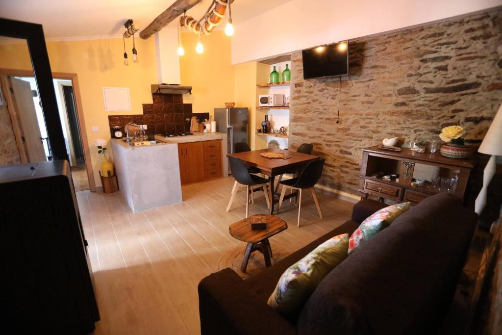 ein Wohnzimmer mit einem Sofa und einem Tisch sowie eine Küche in der Unterkunft Casa Imperatriz in Vilar de Ledra