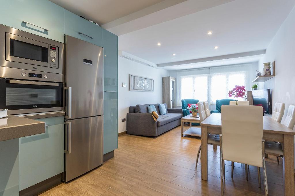 uma cozinha e sala de estar com um frigorífico de aço inoxidável em Apartments Vistas Mar Bahia em Cádiz