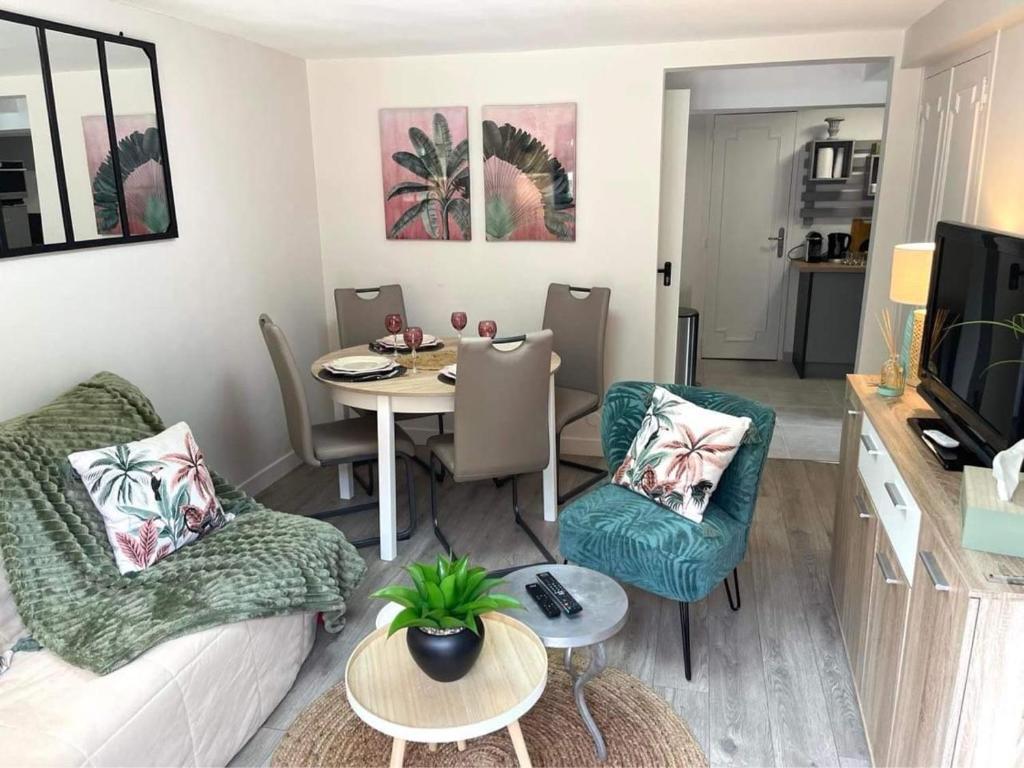 a living room with a couch and a table with chairs at GITE L'Orée Deauvillaise 5 minutes DeauvilleTrouville in Bonneville-sur-Touques