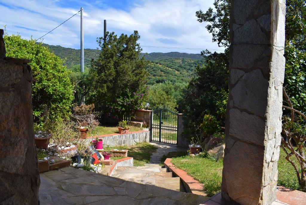 vistas a un jardín con puerta y árboles en Villa azzurra tra le coste del sud en Villasimius