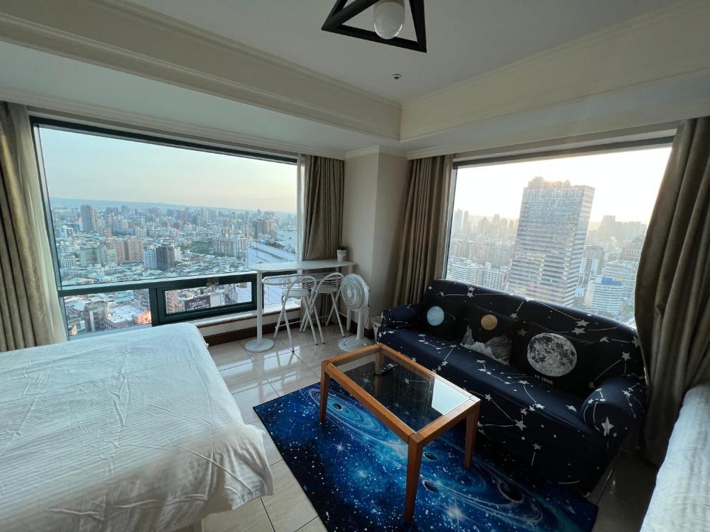 a room with a bed and a couch and large windows at 台中H高樓景觀宅High-Rise Taichung in Taichung