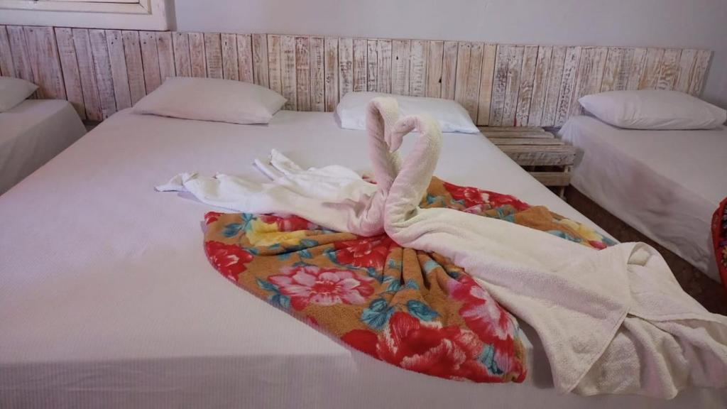 a bedroom with two beds with towels on them at Portal Cores in Porto De Galinhas