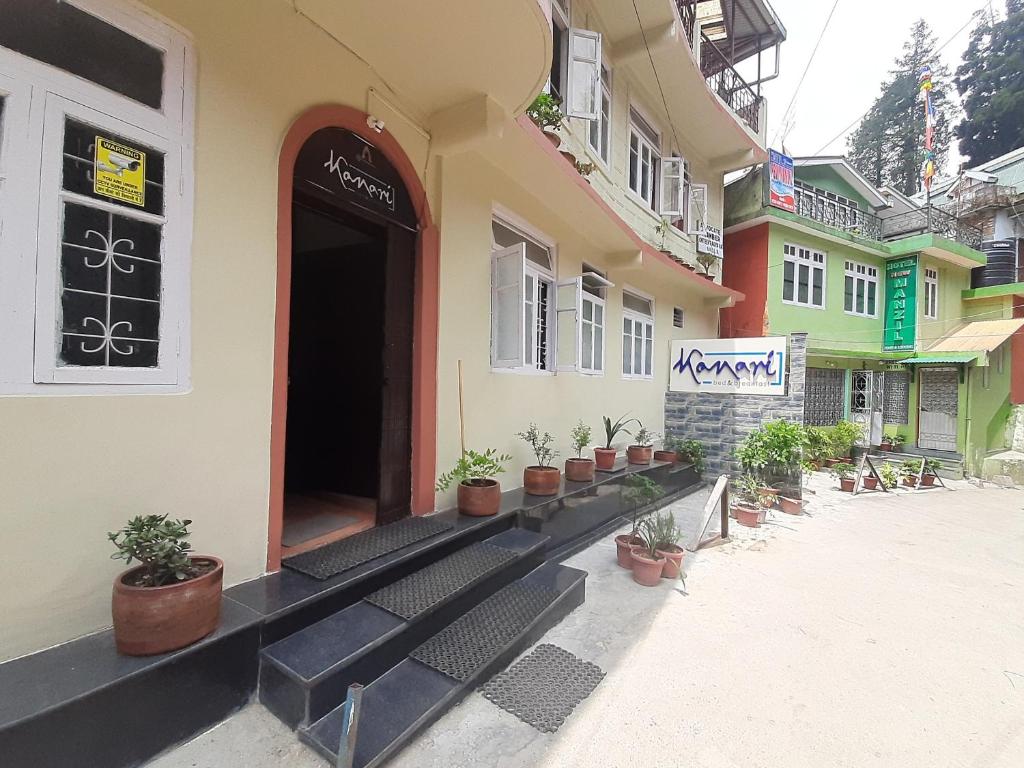 a building with potted plants sitting outside of it at Kanari B&B in Darjeeling