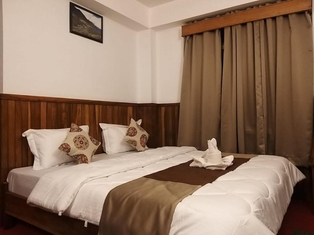 a hotel room with two beds with pillows at Roys Rabdentse Residency in Pelling