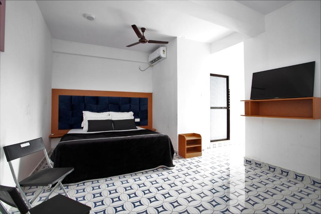 a bedroom with a bed and a flat screen tv at TM Calangute House Stay at Goa in Calangute