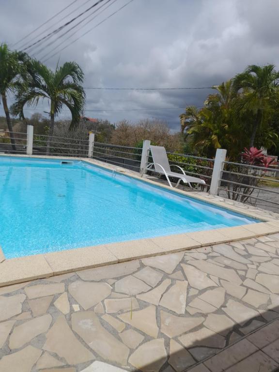 een groot zwembad met twee stoelen ernaast bij ZEN'O devilla in Sainte-Anne