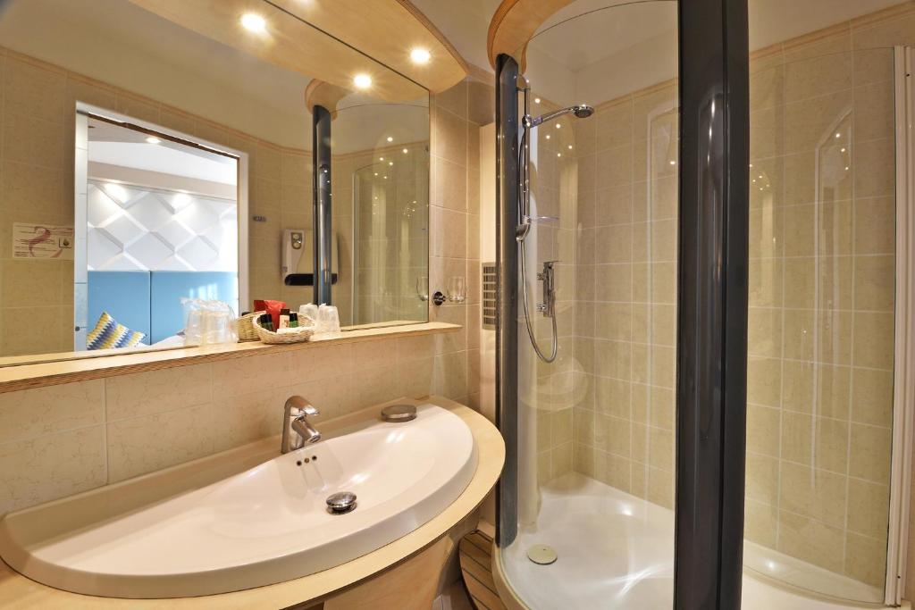 a bathroom with a sink and a shower at Hotel Tettola in Saint-Florent