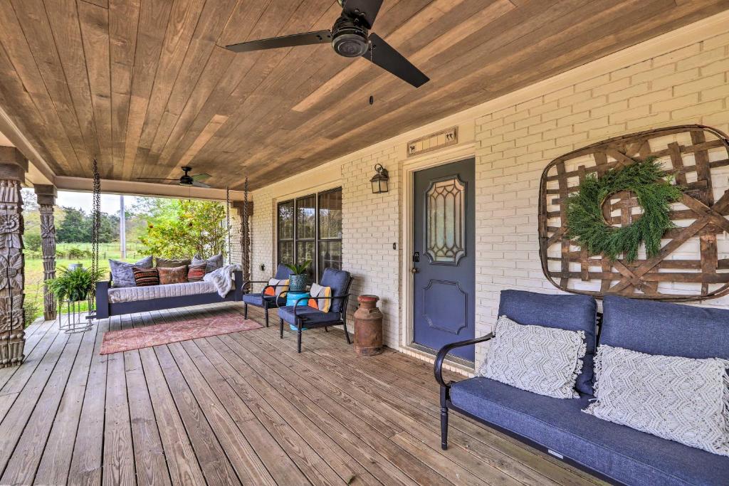eine Veranda mit blauen Möbeln und einem Deckenventilator in der Unterkunft Charming Retreat on 80-Acre Willow Rock Ranch! in Warm Springs