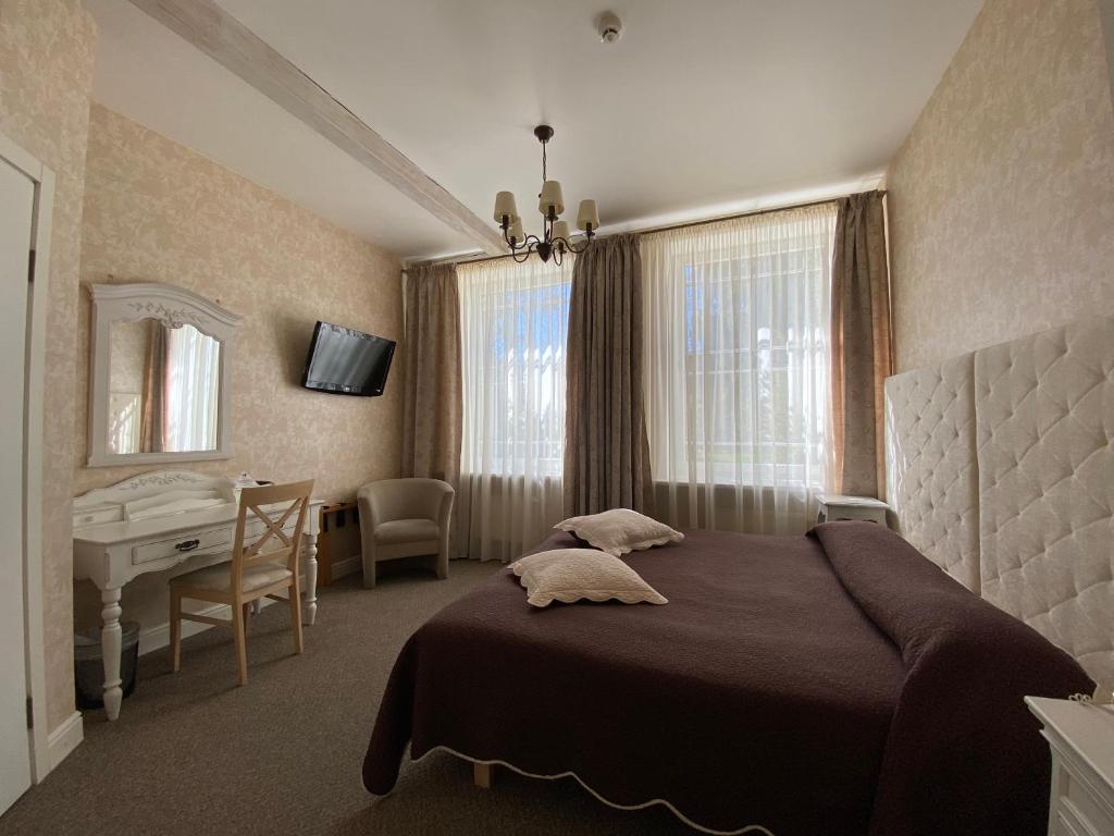 a bedroom with a bed and a table and a desk at Villa Joma in Jūrmala