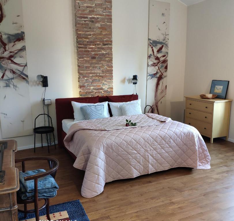 ein Schlafzimmer mit einem Bett und einer Ziegelwand in der Unterkunft Relaxing Retreat in the Center of Friuli in Ontagnano
