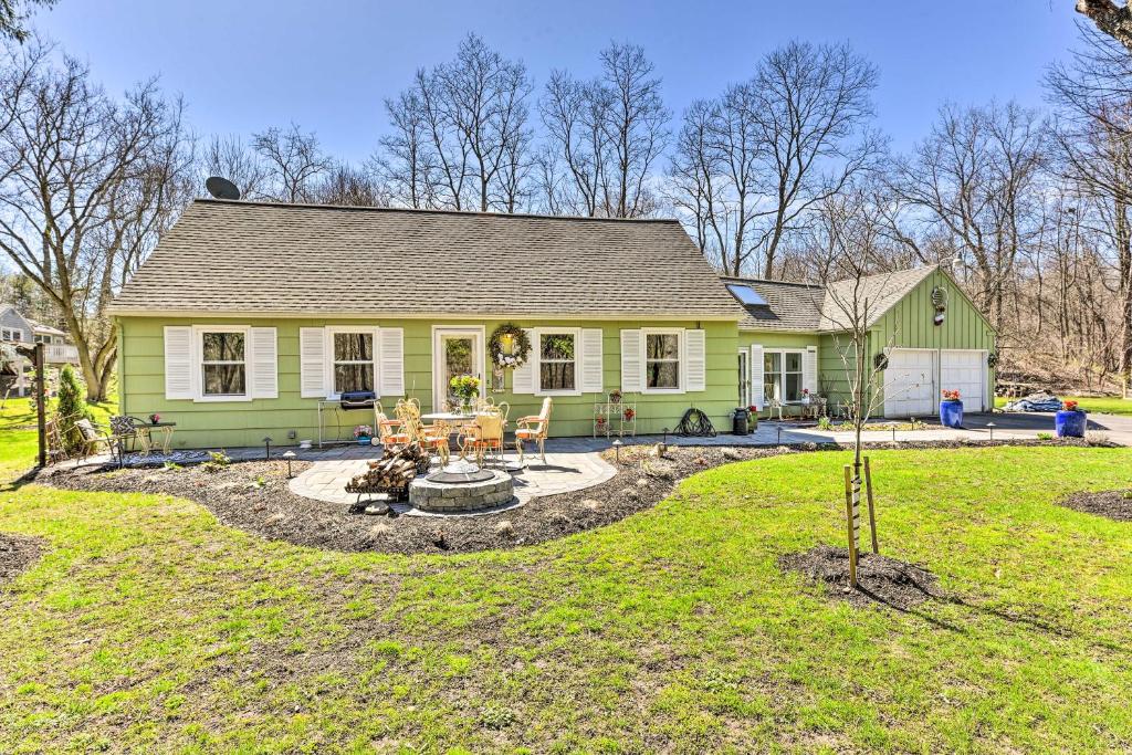 a green house with a fire pit in the yard at Pittsford Trolley Home - Near Erie Canal! in Pittsford