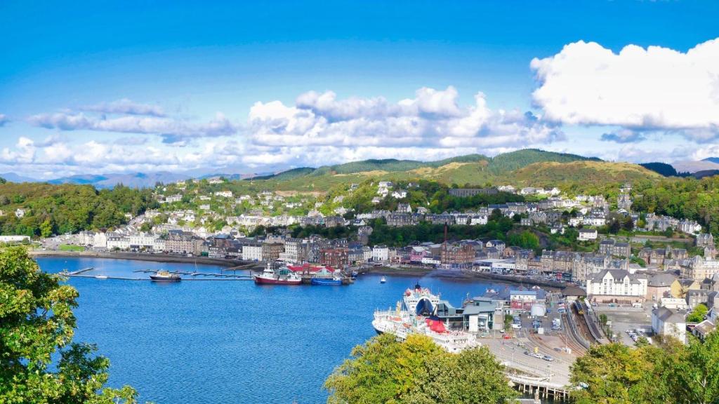 a view of a city with boats in a river at McCaig's Tower Apartment in Oban