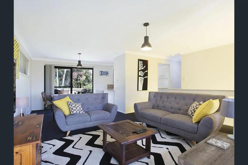 a living room with two couches and a coffee table at Bright Private Room in Pleasant Ashmore in Gold Coast