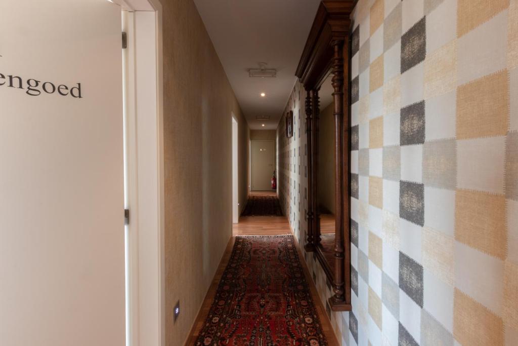 a hallway with a rug on the floor and a tile wall at Apollonia in Aalter