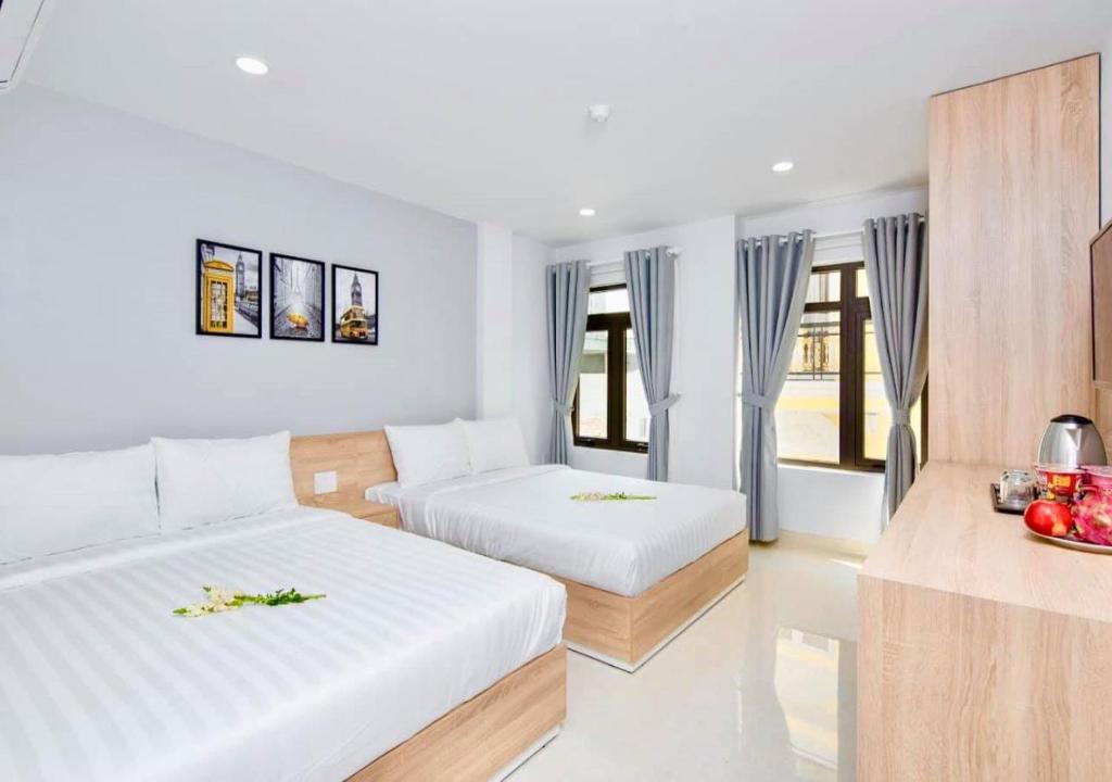 a hotel room with two beds and a table at Luna House Danang in Danang