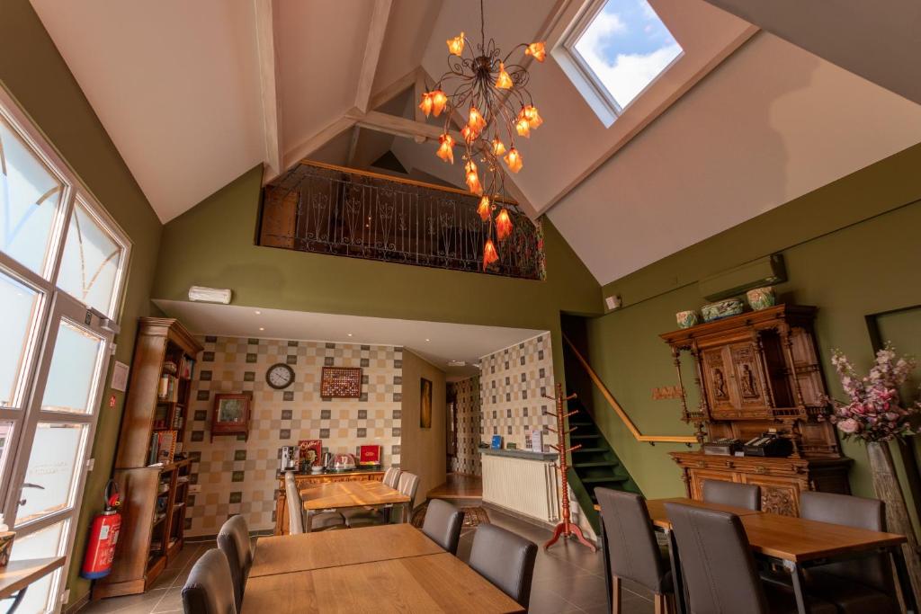 a dining room with a table and chairs and a chandelier at Apollonia in Aalter