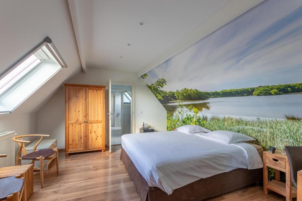 a bedroom with a large bed with a painting on the wall at Apollonia in Aalter