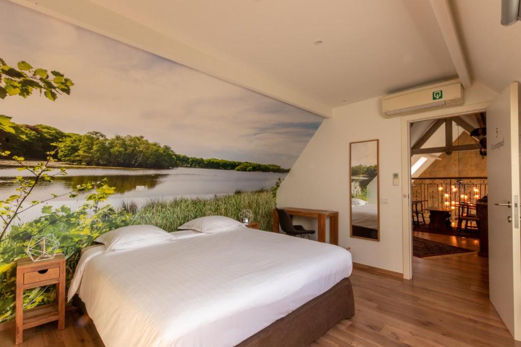 a bedroom with a bed and a painting of a river at Apollonia in Aalter