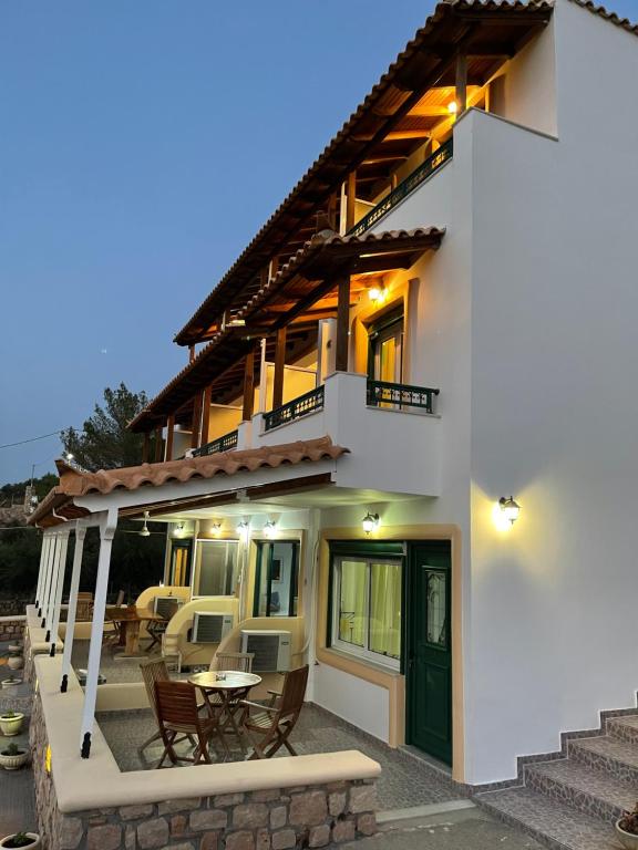 a large white house with a table and chairs at Niriides Rooms in Elafonisos