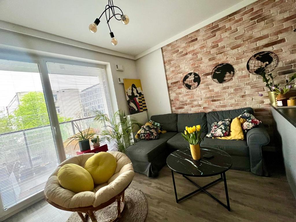sala de estar con sofá y pared de ladrillo en Konstruktorska Chill, en Varsovia