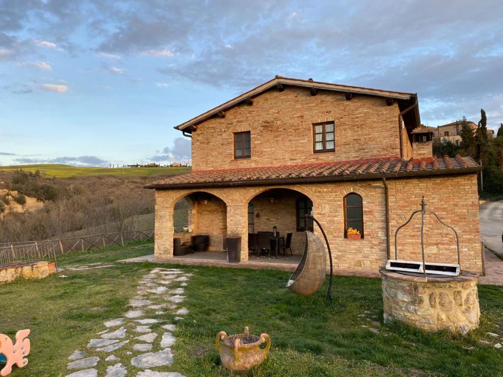 a brick house with a playground in the yard at La casina di Helen in Montalcino