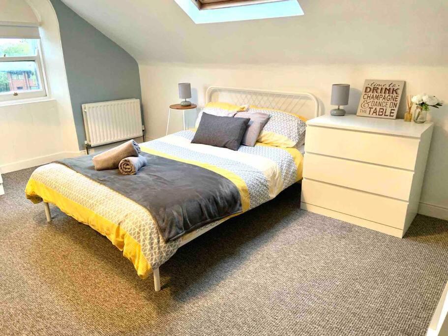 a bedroom with a large bed and a dresser at Flat 7 EIA House in Belfast