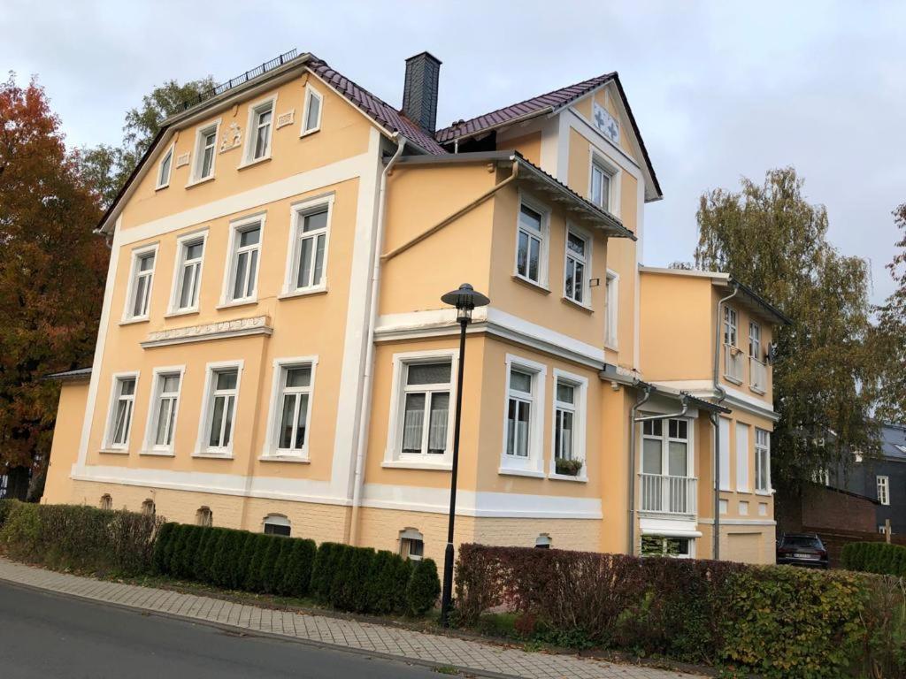 un edificio amarillo con un reloj encima en Ferienwohnung Bad Laasphe Altstadt, en Bad Laasphe