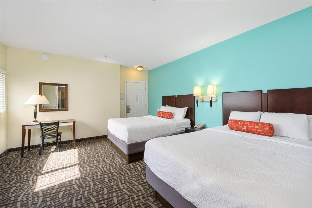 a hotel room with two beds and a desk at Monte Carlo Condos Ocean City in Ocean City