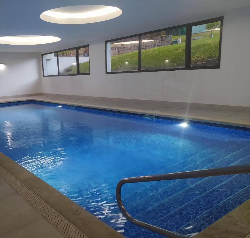 a large swimming pool with blue water in a building at Apartamento Edificio Unique, Punta del Este in Punta del Este